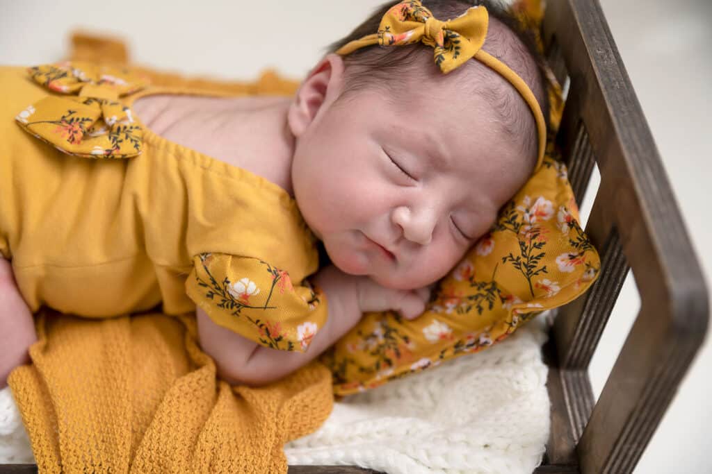 baby girl in yellow outfit with yellow headband