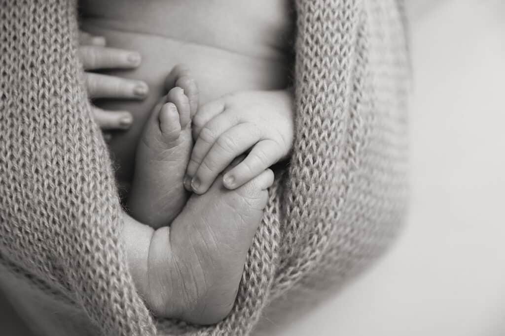 newborn baby holding toes close up detail shot