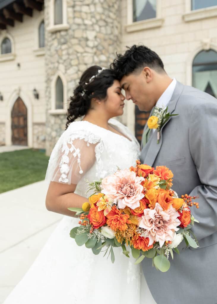 bride and groom with orange and pink bouquet
