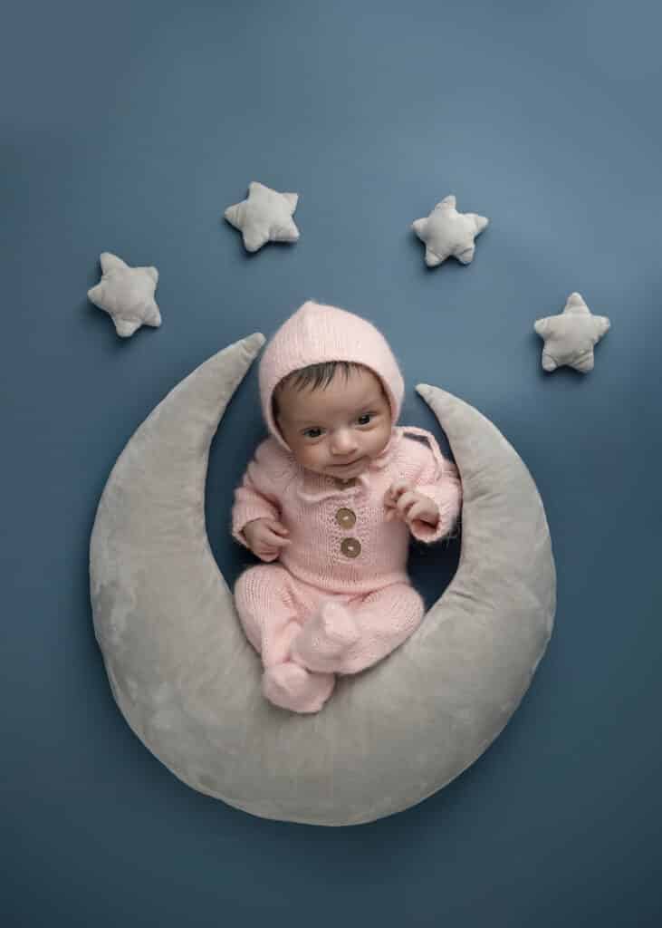 cutest newborn portrait with baby on moon next to stars taken by a utah county newborn photographer