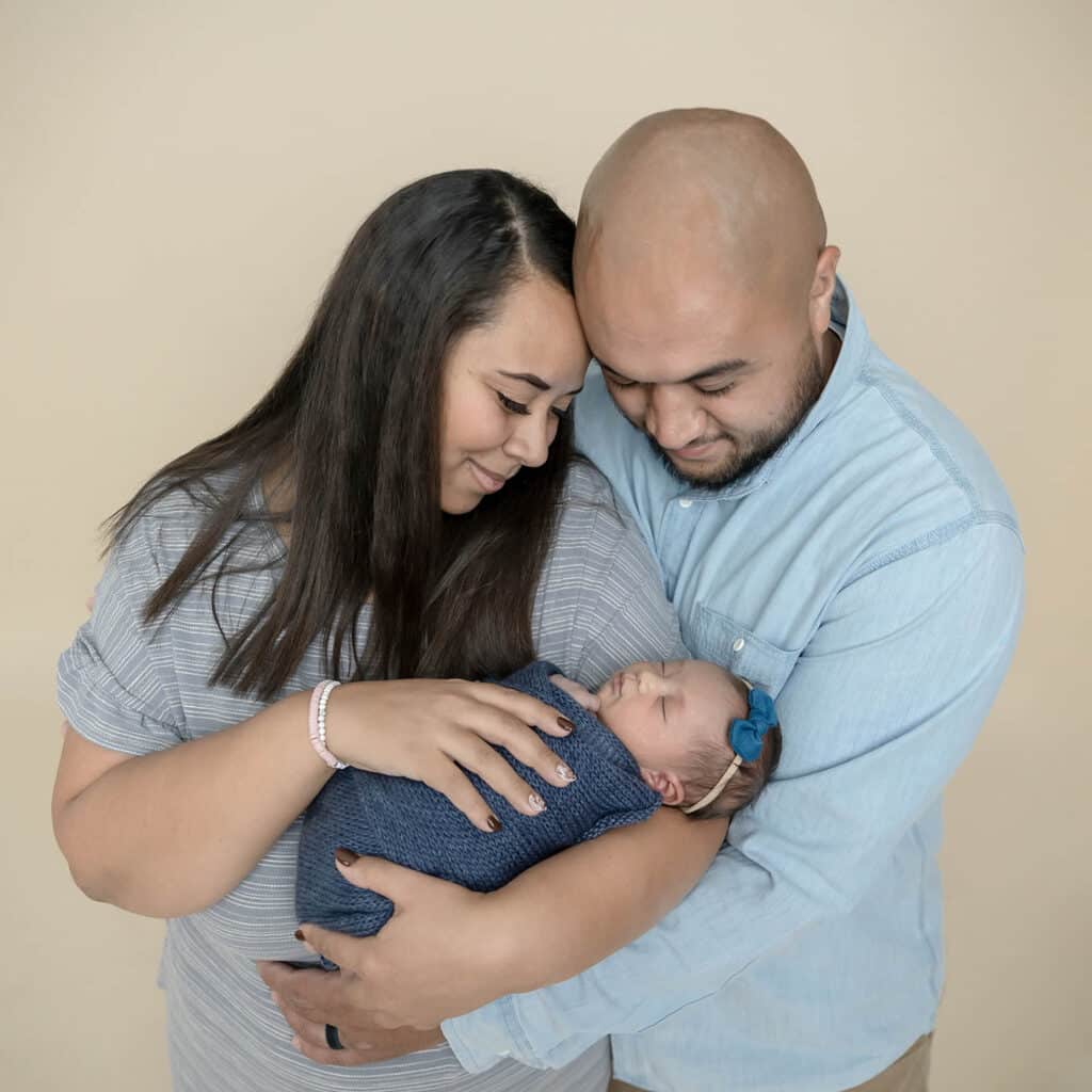 newborn baby held by mom and dad