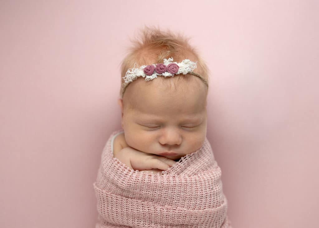 newborn baby on pink blanket