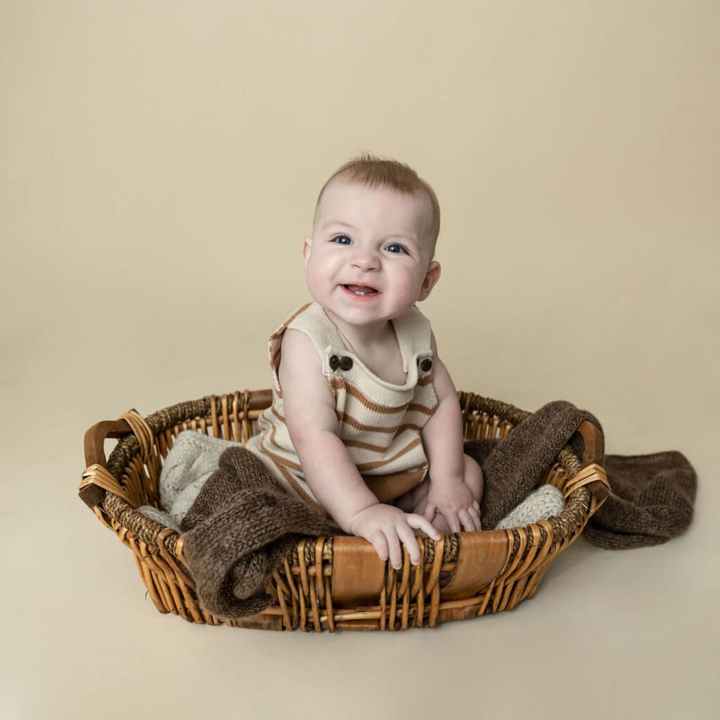 baby boy smiling in a basket