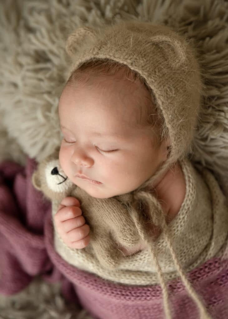 newborn girl with brown teddy bear