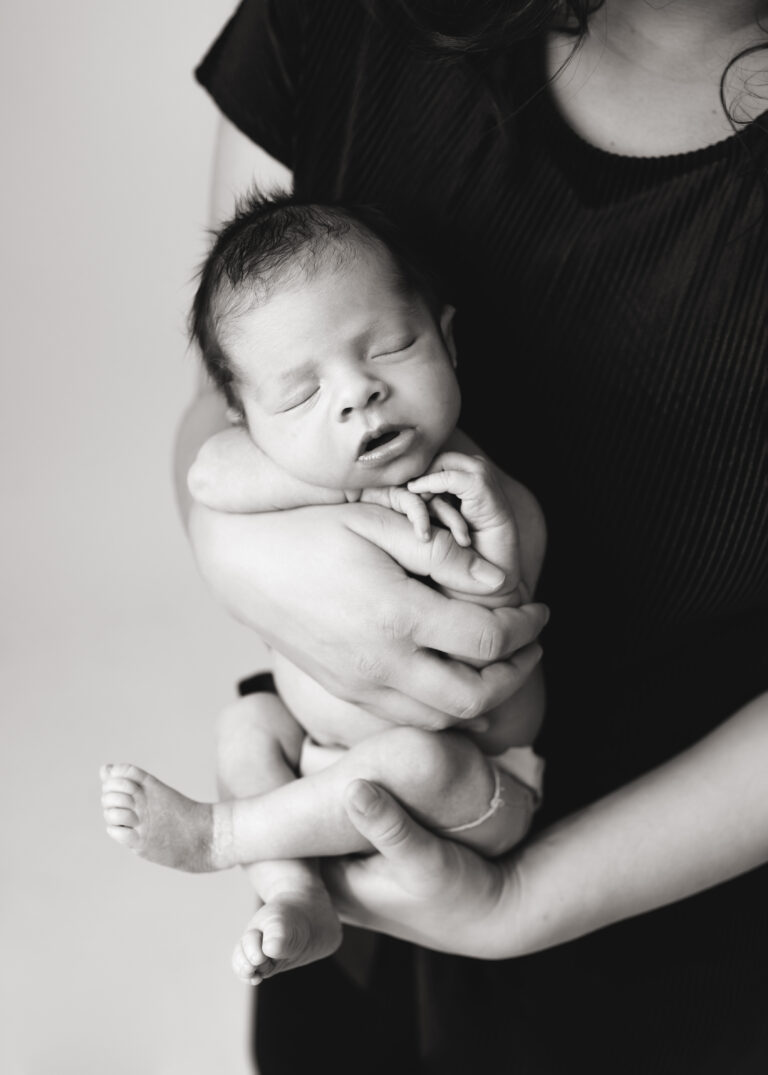 newborn photographer baby picture black and white mom holding baby in hands provo newborn photographer