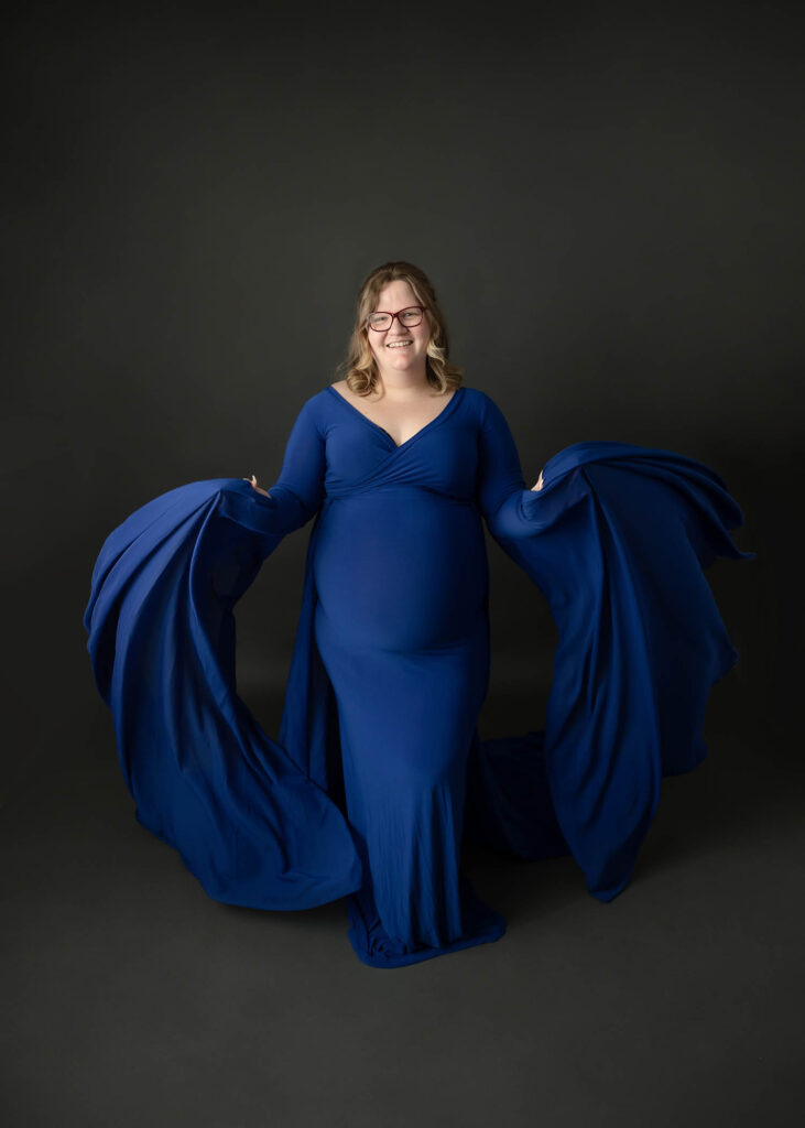 pregnant mom in blue maternity gown with long flowing sleeves