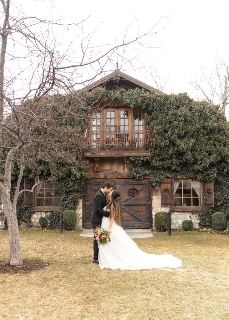 bride and groom in front of cute cottage covered with ivy