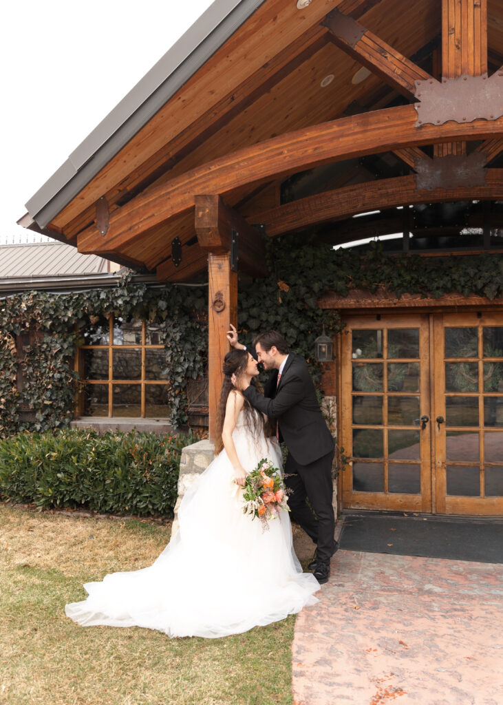bride and groom in front of reception center in utah