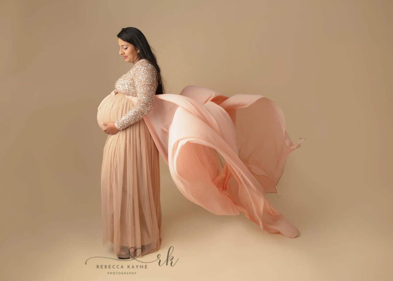 mom wearing flowy pink maternity gown for maternity session