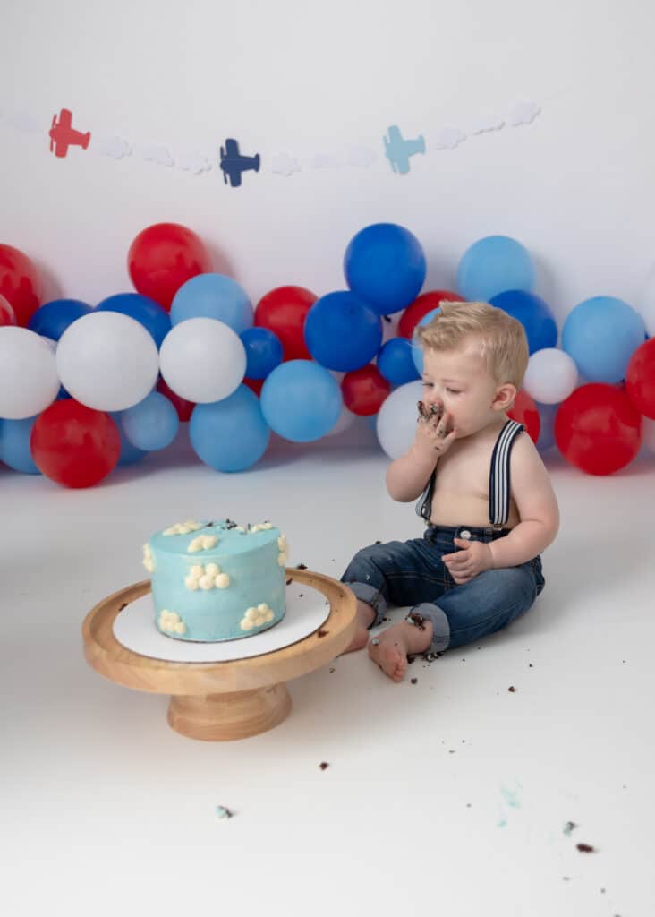 utah county cake smash with baby on an airplane theme with cloud covered cake