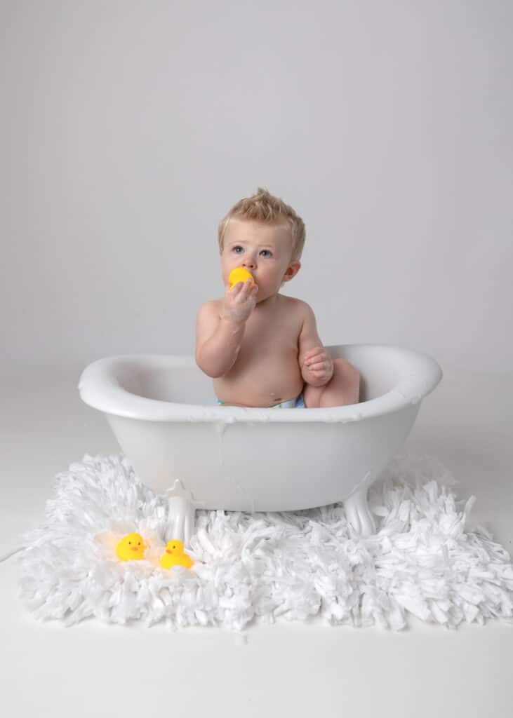 baby in tub with rubber ducky after cake smash session