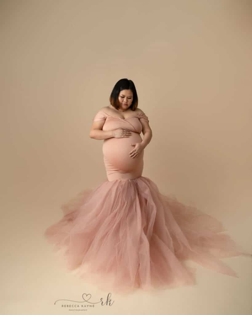 beautiful pink maternity gown in mermaid style with full tulle train for rent from maternity gown rental company in utah