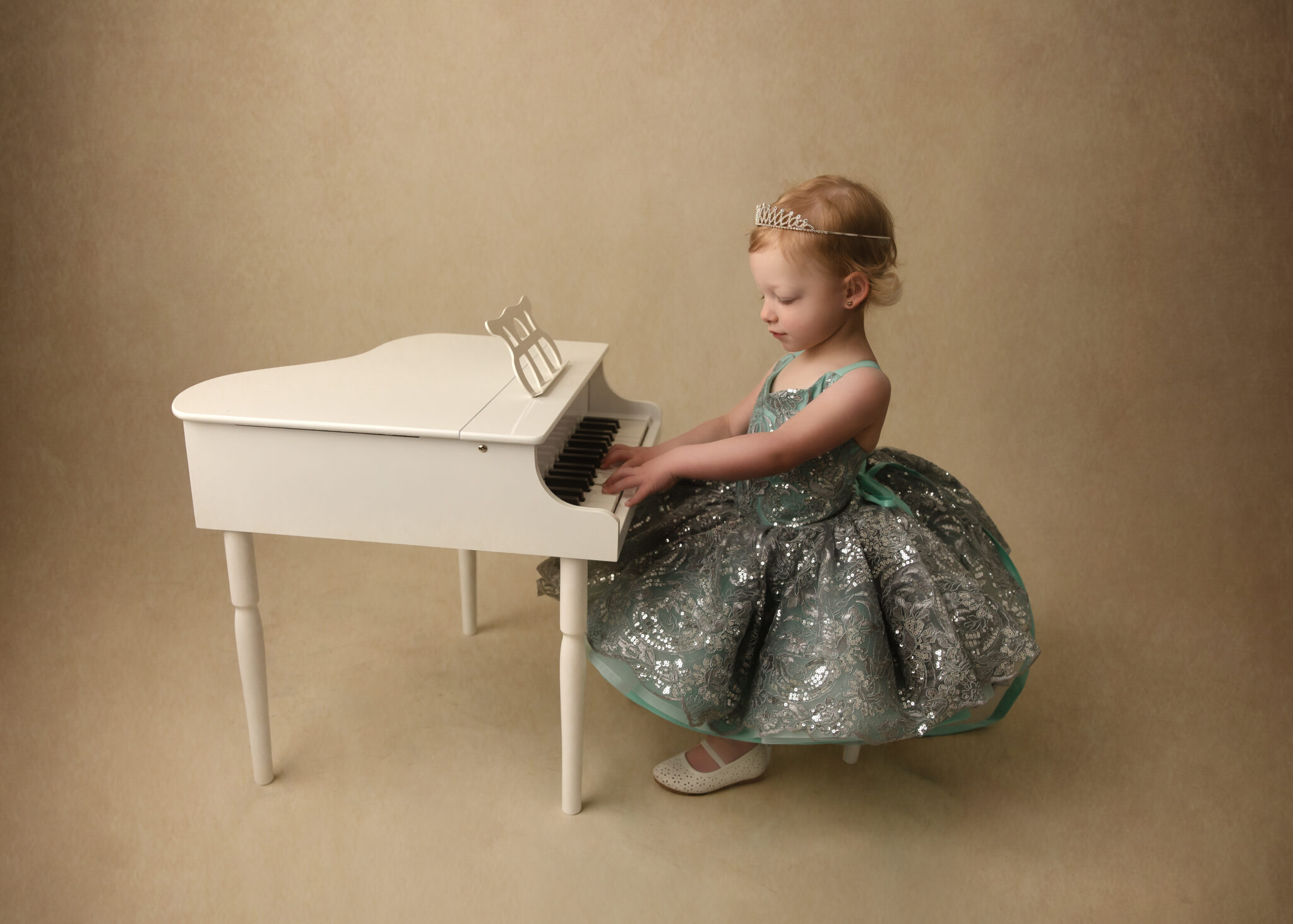 little girl at a piano for her princess photography session